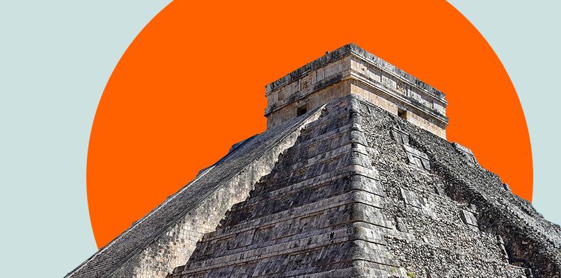 Image of the pyramid of Chichen Itza in Mexico, showcasing its ancient stone architecture. The pyramid stands prominently against a backdrop featuring a bold, orange circle, giving a modern and striking visual contrast to the historic structure.